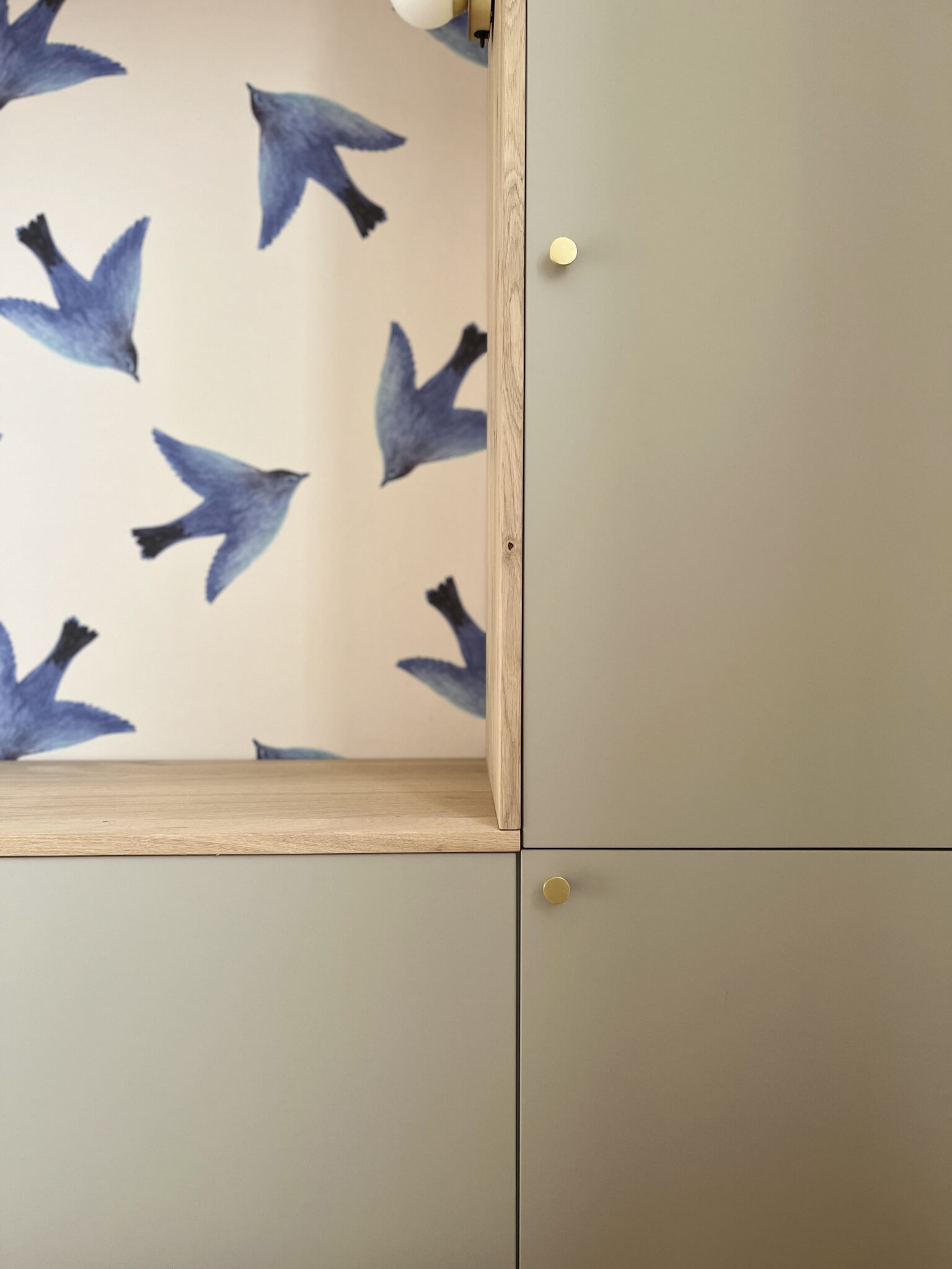 zoom sur un meuble sur mesure avec des niches et un papier peint oiseaux pour enfant